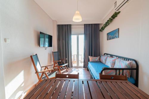a living room with a blue couch in a room at Seagull House by RentalsPro - Nea Potidaia Hlkidiki in Nea Potidaea