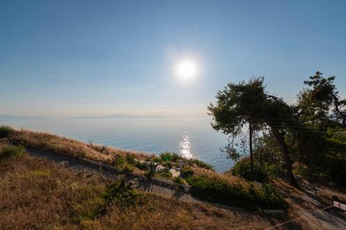 a view of the ocean with the sun in the sky at Seagull House by RentalsPro - Nea Potidaia Hlkidiki in Nea Potidaea