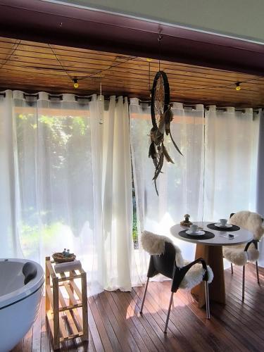 a bathroom with a bath tub and a table and a bath tub at Chalés Recanto dos Sonhos in Camanducaia