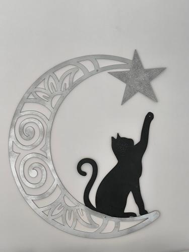 a black cat sitting on the moon and a star at Chalés Recanto dos Sonhos in Camanducaia