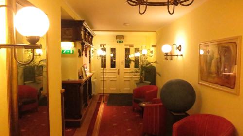 a room with a hallway with chairs and a light at Hotel Elefant in Schwerin