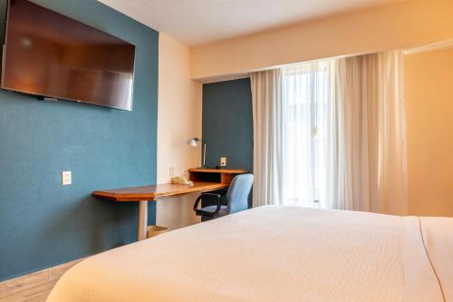 a hotel room with a bed and a desk at Fiesta Inn Poza Rica in Poza Rica de Hidalgo