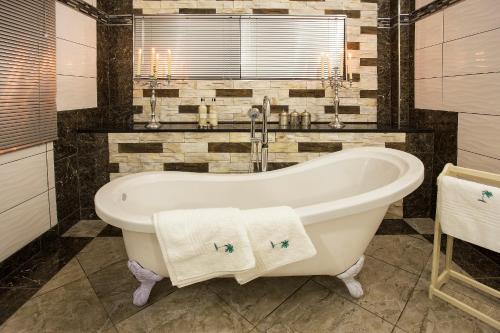 a bathroom with a bath tub with two towels at The Royal Palm B&B in Ohrigstad