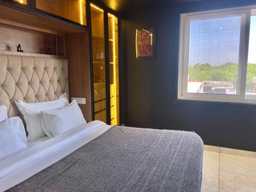 a bedroom with a large bed with a window at Boutique Apartments By One Tree in Jodhpur