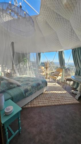 a bedroom with a large bed with a canopy at Logements insolites du Domaine de la Tuilière in Carnoules