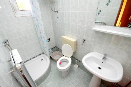 une salle de bain avec des toilettes blanches et un lavabo dans l'établissement Appartements Prisika Novi, à Novi Vinodolski
