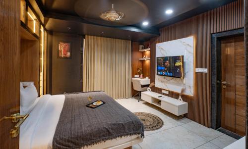 a bedroom with a bed and a sink and a tv at Boutique Apartments By One Tree in Jodhpur