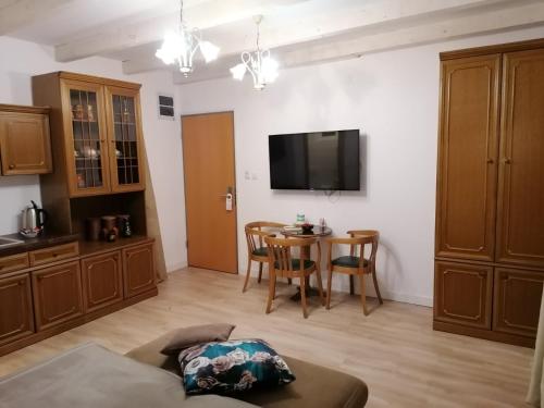 a living room with a table and a tv on the wall at Apartments 135 in Vršac