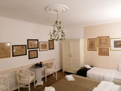 a bedroom with a bed and a table and a chandelier at Apartments 135 in Vršac