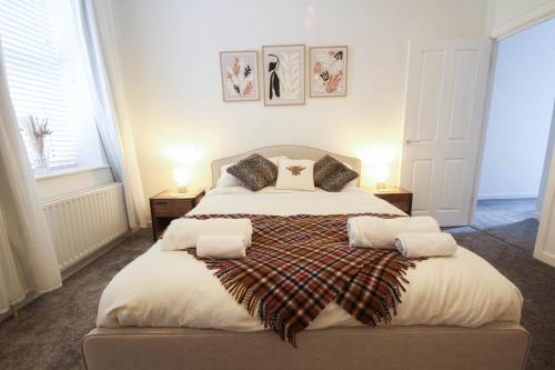 a bedroom with a large bed with two pillows at Spacious Home - 4 Bedrooms - Sleeps 9 - FREE Superfast 1GB Wi-Fi - 55" Smart TV - FREE Parking in Newcastle upon Tyne
