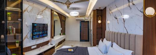 a room with a bed and a tv on a wall at Boutique Apartments By One Tree in Jodhpur