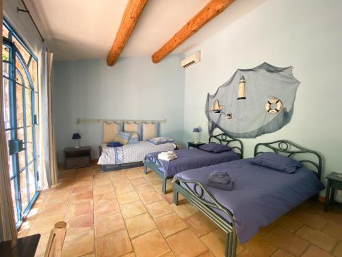 due letti in una stanza con pareti blu di Bergerie a Grimaud