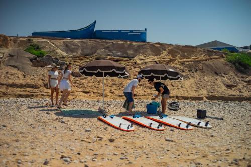 a group of people standing on a beach with surfboards at Panorama Guesthouse in Agadir
