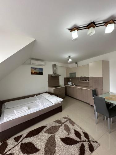 a bedroom with a bed and a table and a kitchen at Art Apartments in Hajdúszoboszló