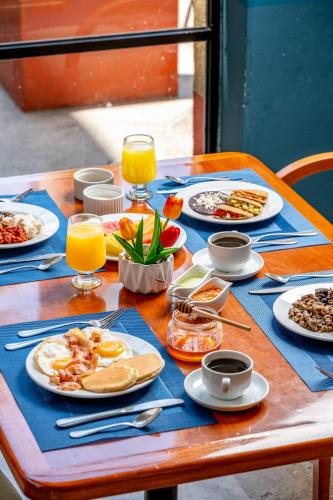 a wooden table with plates of food on it at Fiesta Inn Poza Rica in Poza Rica de Hidalgo