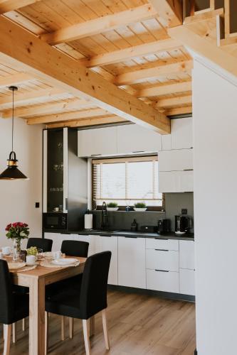 a kitchen with white cabinets and a wooden table at Słoneczne Wzgórze in Zagórze Śląskie