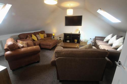 a living room with couches and a tv at Spacious Home - 4 Bedrooms - Sleeps 9 - FREE Superfast 1GB Wi-Fi - 55" Smart TV - FREE Parking in Newcastle upon Tyne