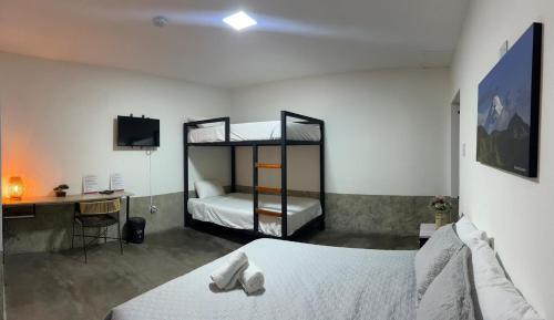 a bedroom with two bunk beds and a desk at Nómada22 -Hostal moderno en el centro de Neiva in Neiva