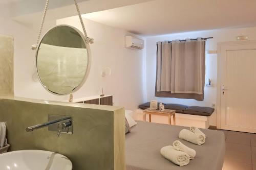 a bathroom with a sink and a mirror at Ambience Suites in Firostefani