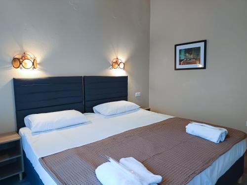 a bedroom with a bed with two white towels on it at Yannis Hotel in Krinídhes
