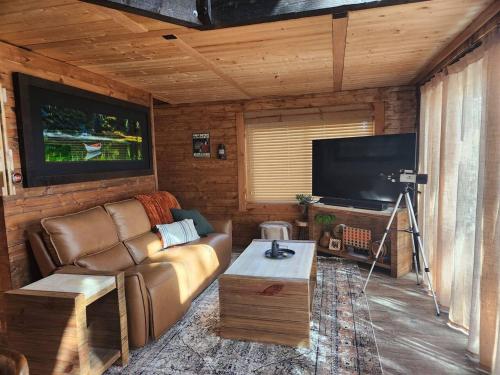 a living room with a couch and a flat screen tv at Rim Overlook Cabin Retreat in Duck Creek Village