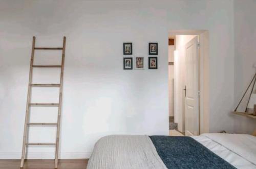 une chambre avec une échelle à côté d'un mur blanc dans l'établissement Le Clos St Georges, à Toulouse