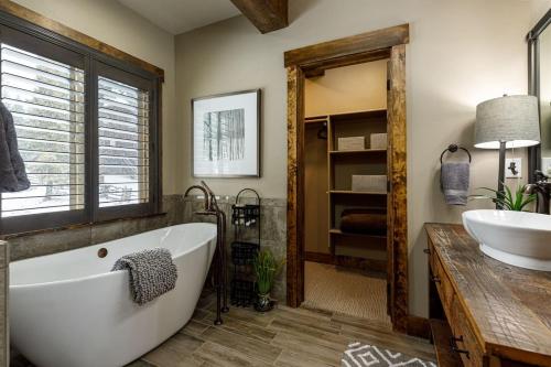 a bathroom with a large tub and a sink at Mossberg Luxury Retreat in Duck Creek Village
