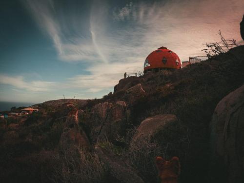 una cúpula roja en la cima de una colina rocosa en DomoChango, en La Serena