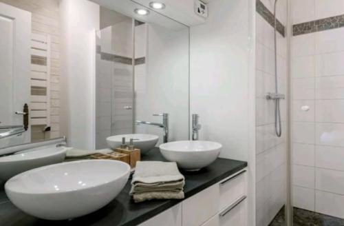 une salle de bain avec deux lavabos et un miroir dans l'établissement Le Clos St Georges, à Toulouse