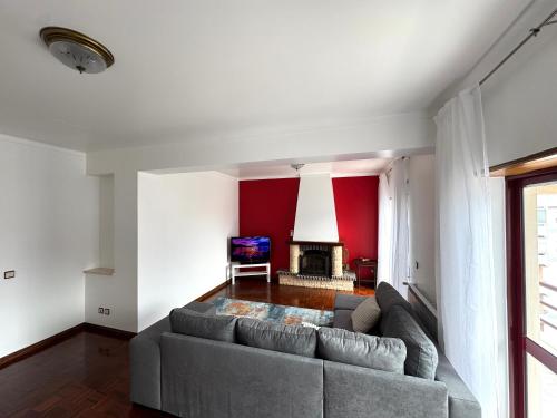a living room with a couch and a fireplace at 3 Bedroom Apt 15 Min Walk to Fátima Sanctuary in Fátima