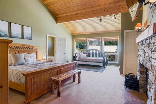 ein Schlafzimmer mit einem Bett und einer Couch und einem Kamin in der Unterkunft Aspen Summit Retreat in Brian Head