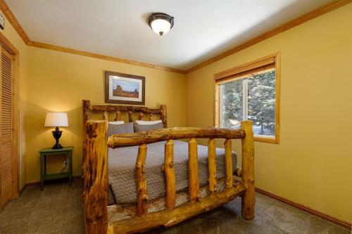 una camera da letto con un letto di legno e una finestra di Pine View Cabin Retreat, Hot Tub, Walk Out Patio a Duck Creek Village