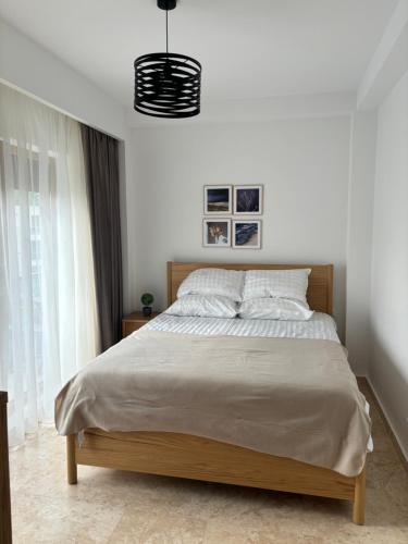 a bedroom with a bed and a pendant light at La Dolce Riva Apartments - Navodari Mamaia-Sat in Mamaia Nord