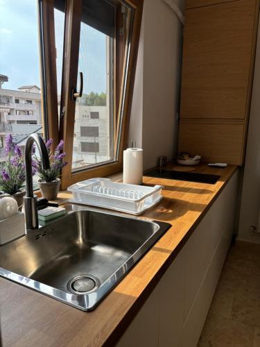 a kitchen counter with a sink and a window at La Dolce Riva Apartments - Navodari Mamaia-Sat in Mamaia Nord