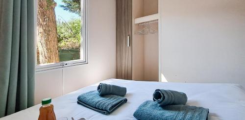 - un lit avec 2 oreillers et une fenêtre dans l'établissement Temps Suspendu - 7 kms plage - Confort - Lumineux - Détente, à Saint-Hilaire-de-Riez