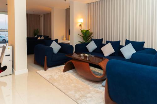 a living room with a blue couch and a table at شقق همس البحر Hams Apartments in Ḑubā