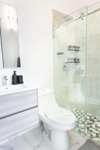 a white bathroom with a toilet and a shower at 3 Bed 2 Bath A 8 Family House w Private Pool Dorado del Mar in Dorado