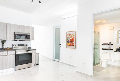 a white kitchen with a stove top oven next to a toilet at 3 Bed 2 Bath A8 Family House w Private Pool Dorado del Mar in Dorado
