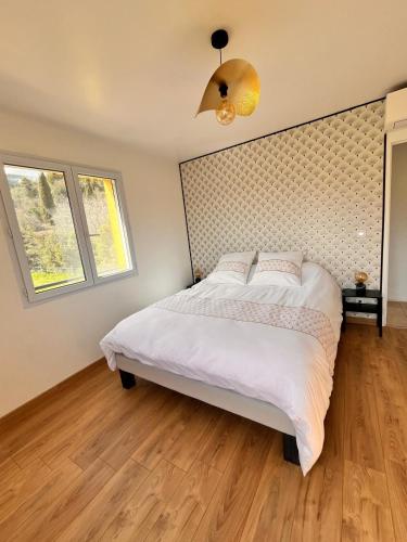 une chambre avec un grand lit blanc dans une pièce dans l'établissement Maison familiale au calme, à Carros