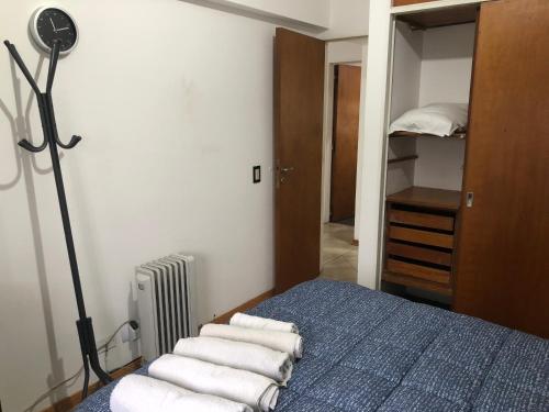 a bedroom with a bed and a closet with towels at LA CASITA in Buenos Aires