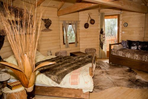 a bedroom with a bed in a log cabin at Logements insolites du Domaine de la Tuilière in Carnoules