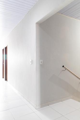 a white room with a white wall and a railing at Pousada Gonçalves in Tangará