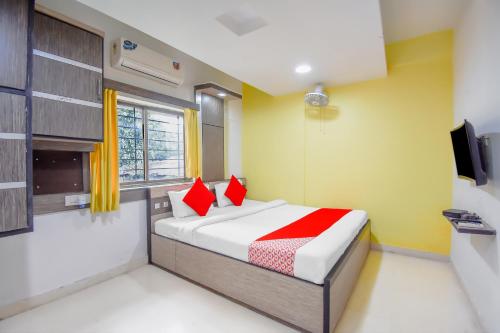 a bedroom with a bed with red pillows at Super hotel O Adri 2 in Kolkata