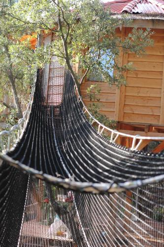 a black hammock in front of a house at Logements insolites du Domaine de la Tuilière in Carnoules