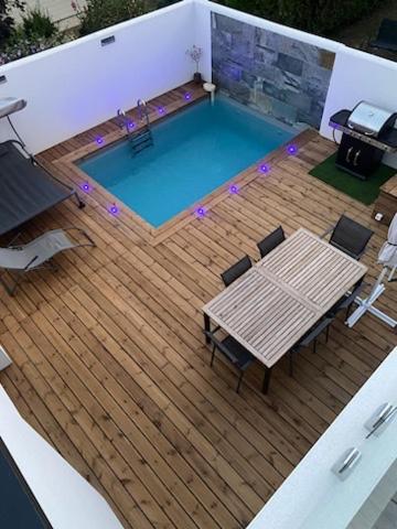- une vue sur la piscine dotée d'une table et de chaises dans l'établissement superbe villa neuve, à Aytré