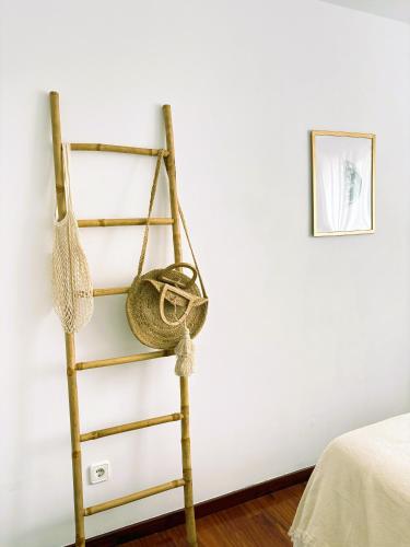 a wooden ladder with a hanging basket in a bedroom at EnBURELA Sol y Playa in Burela de Cabo