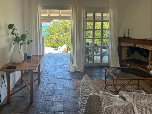 a living room with a fireplace and a table at Studio Coconut in Almirida