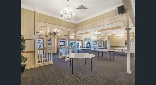 a room with tables and chairs in a building at Amrata Estate in Samford