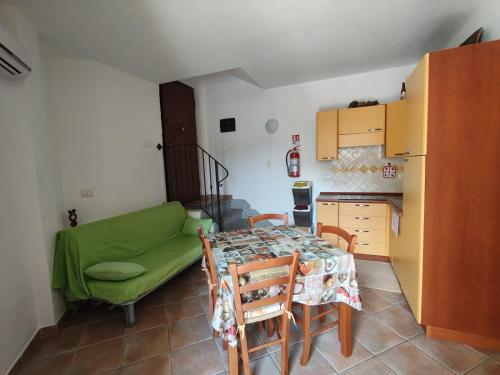 a kitchen with a table and a green couch at Recidence il gabbiano in Valledoria