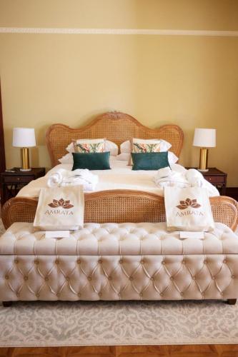 a bedroom with a large bed with a large ottoman at Amrata Estate in Samford